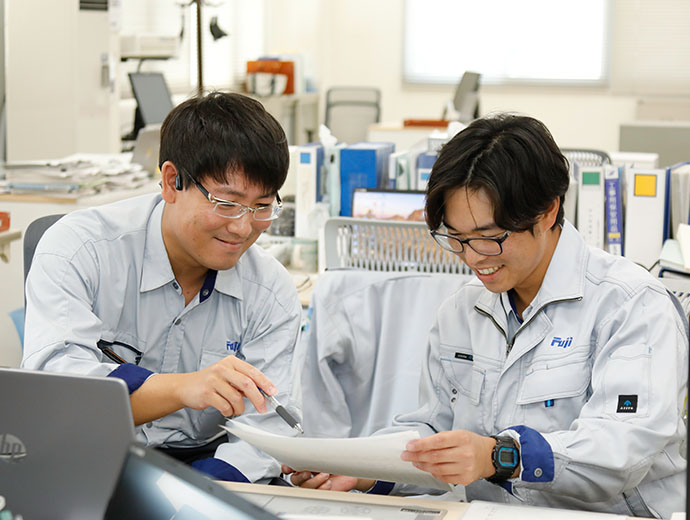 図面を見ながら笑顔で打ち合わせをする職員