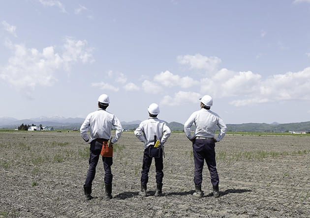 農業土木現場を見つめる男性職員たち